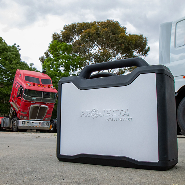 Projecta IS3000 12/24V Intelli-Start Industrial Jump Starter on a road with trucks in the background