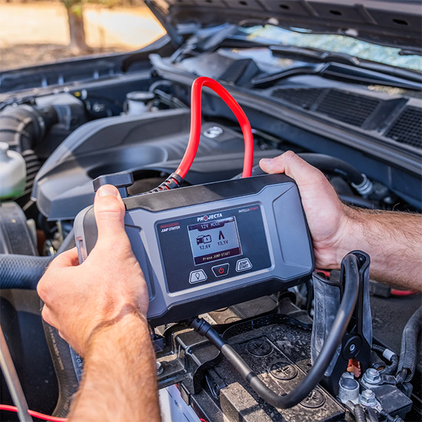 Person using a Projecta IS1400 emergency jump starter on a car